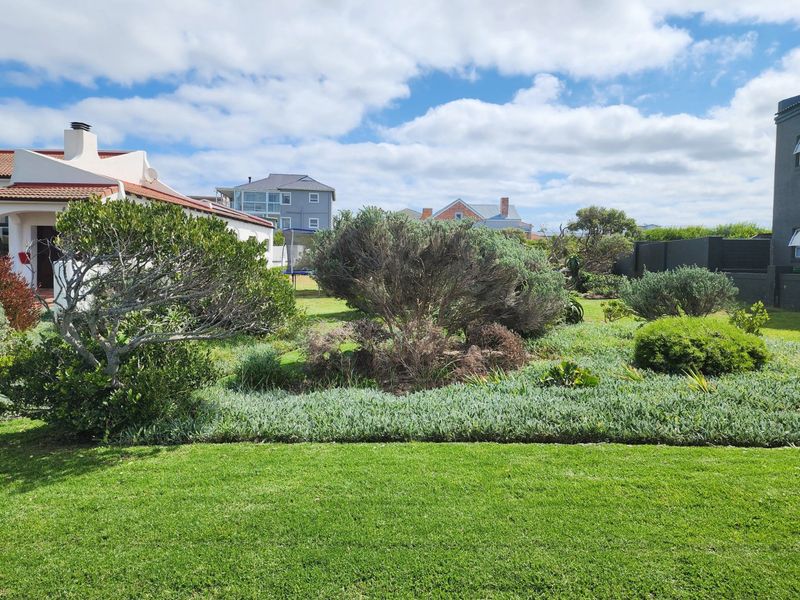 A well-maintained residential garden featuring a manicured lawn and established shrubbery, providing a pleasant outdoor space.