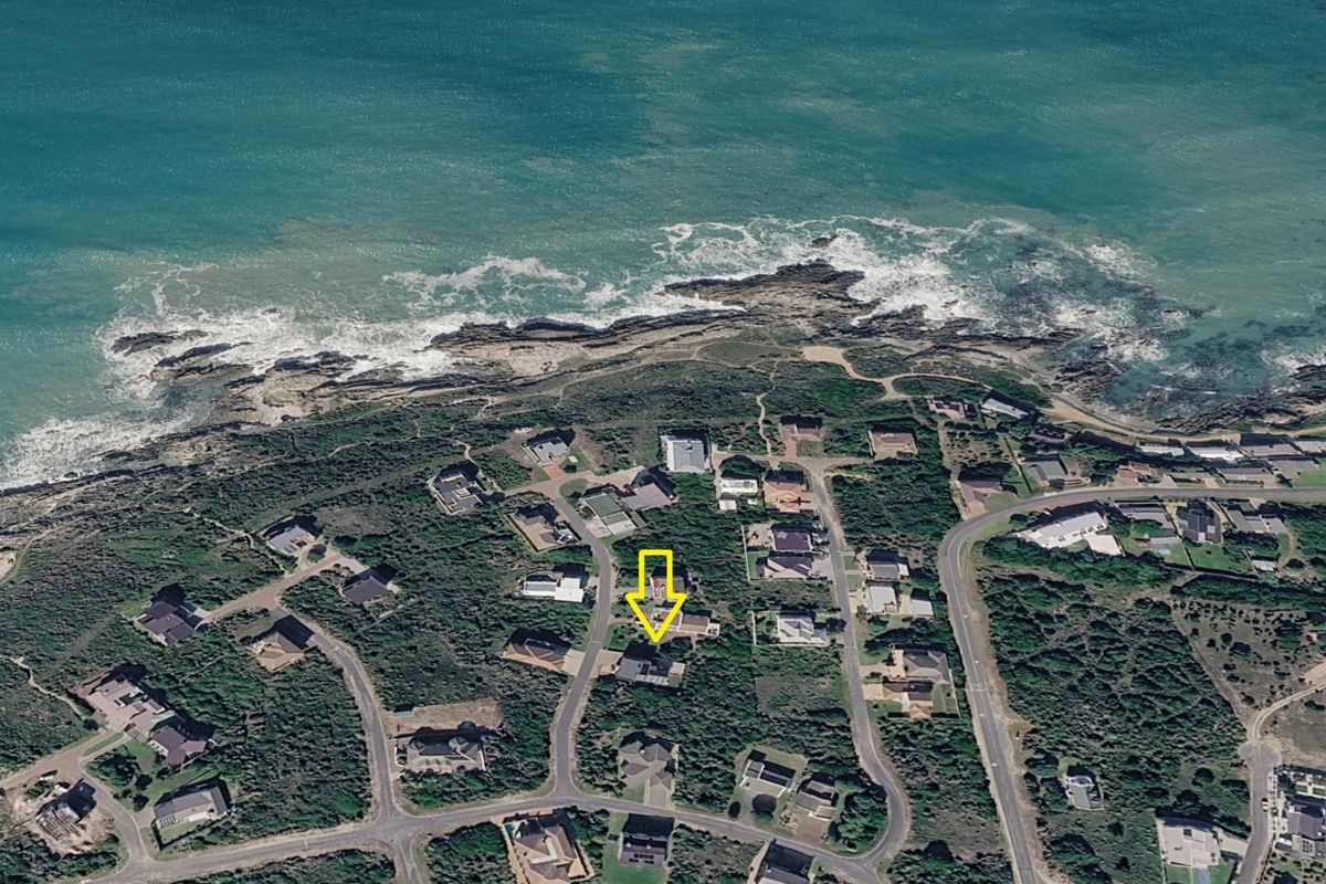 An aerial view of a coastal residential neighborhood, highlighting the property's proximity to the ocean and surrounding landscape.