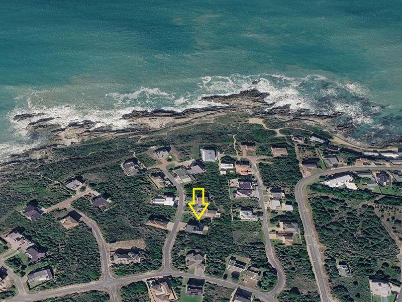An aerial view of a coastal residential neighborhood, highlighting the property's proximity to the ocean and surrounding landscape.