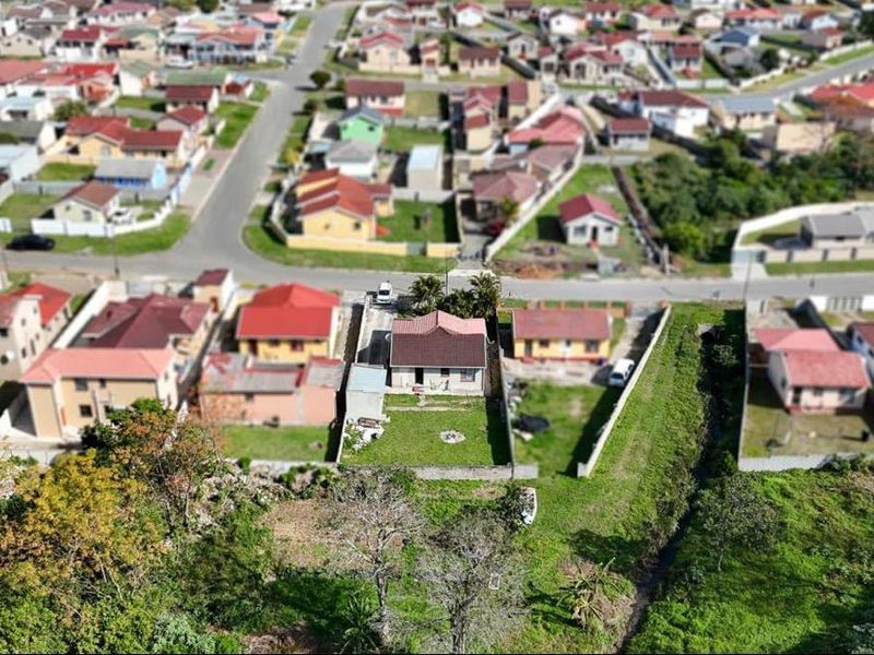 An aerial view of a residential property showing the house, surrounding garden, boundary walls, and the surrounding suburban neighbourhood.