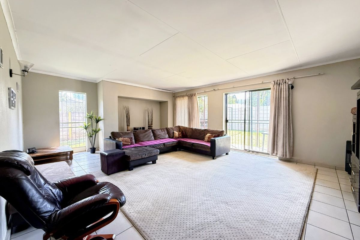 Spacious living room featuring tiled flooring, a recessed wall niche, and sliding glass doors providing access to the outdoor area.
