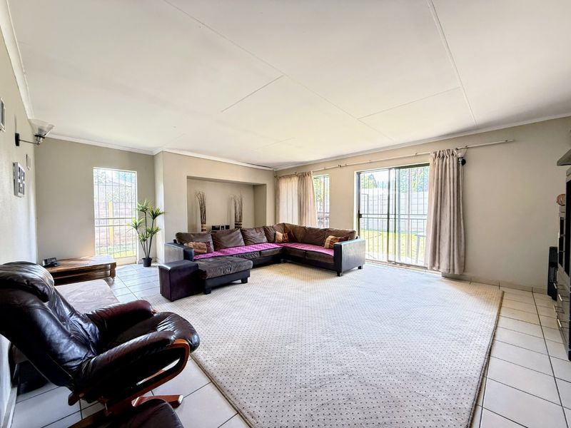 Spacious living room featuring tiled flooring, a recessed wall niche, and sliding glass doors providing access to the outdoor area.
