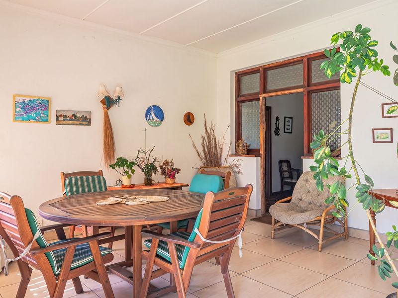 A covered patio area featuring tiled flooring and timber-framed access to the interior, providing a functional outdoor living space.