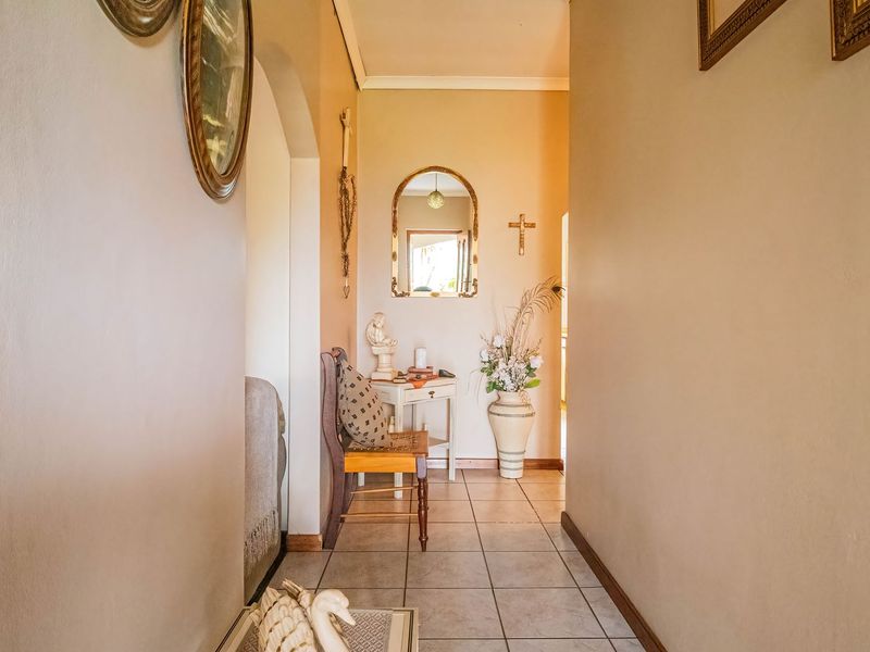 A functional hallway featuring neutral wall tones and durable ceramic floor tiles, providing a clear transition between living spaces.