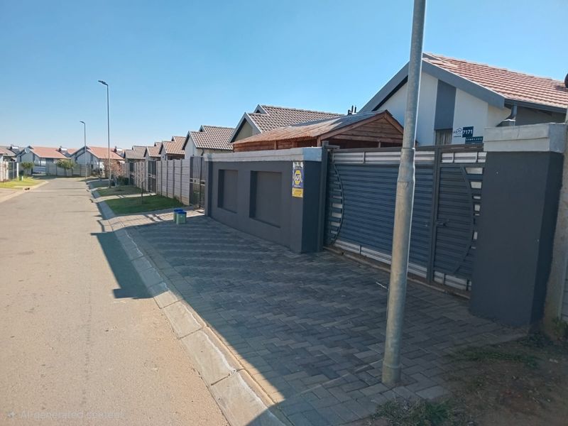 Street view of a residential property featuring a paved driveway, secure perimeter wall, and sliding gate in a suburban neighborhood setting.