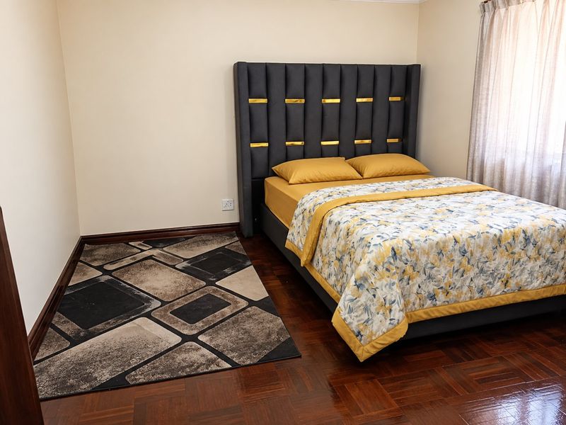 A well-maintained bedroom featuring classic parquet flooring and neutral wall finishes, providing a clean and comfortable living space.