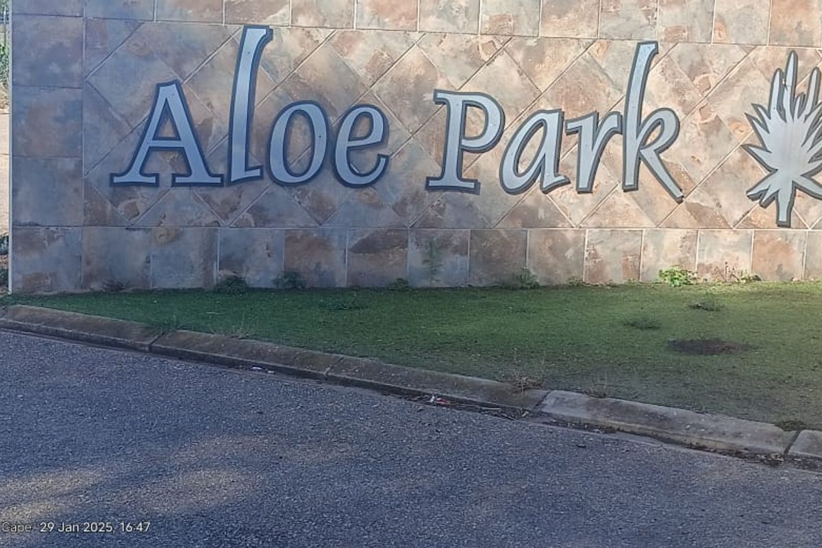 Entrance signage for Aloe Park residential estate featuring stone cladding and paved driveway access.