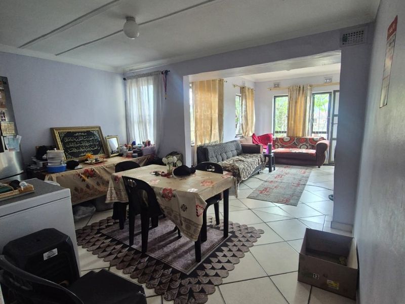 Open plan living and dining area featuring tiled flooring and a connected layout, providing a versatile space for family living.