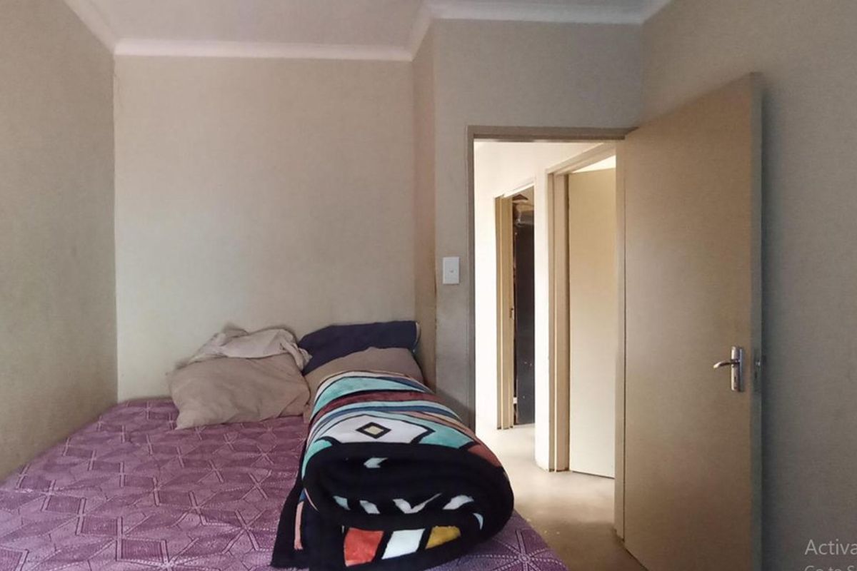 A simple bedroom featuring neutral walls and a standard interior door, providing a functional space for rest.