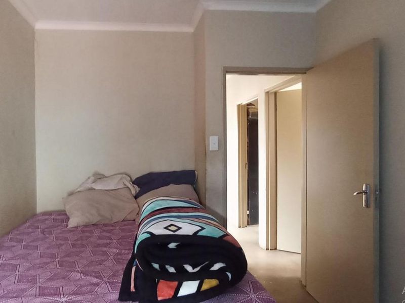 A simple bedroom featuring neutral walls and a standard interior door, providing a functional space for rest.