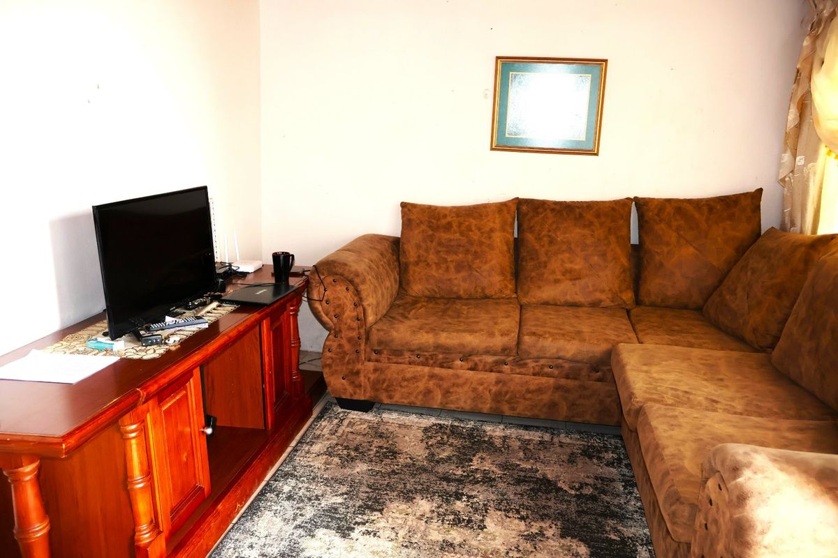 A living room area featuring tiled flooring and neutral wall finishes, providing a functional space for relaxation.