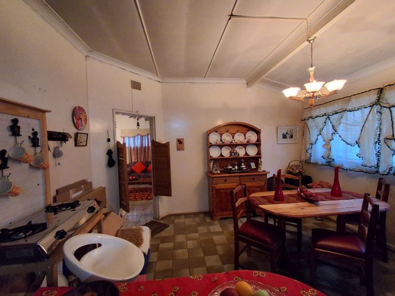 Open plan dining area featuring tiled flooring, coved ceilings, and louvered door access to adjacent living space.