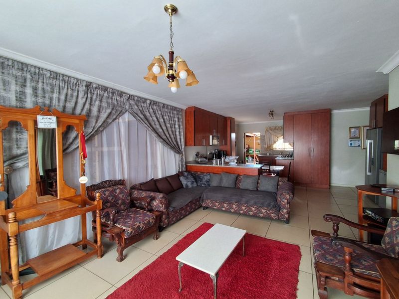 Open-plan living area featuring tiled flooring and a functional kitchen with built-in cabinetry and a breakfast island.
