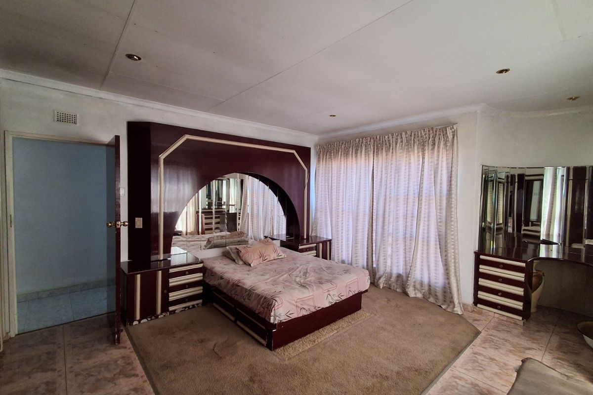 Spacious bedroom featuring built-in cabinetry, tiled flooring, and recessed lighting, offering a functional layout ready for modern updates.