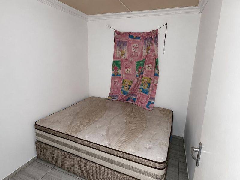 A small bedroom featuring tiled flooring, crown molding, and a central ceiling light fixture.