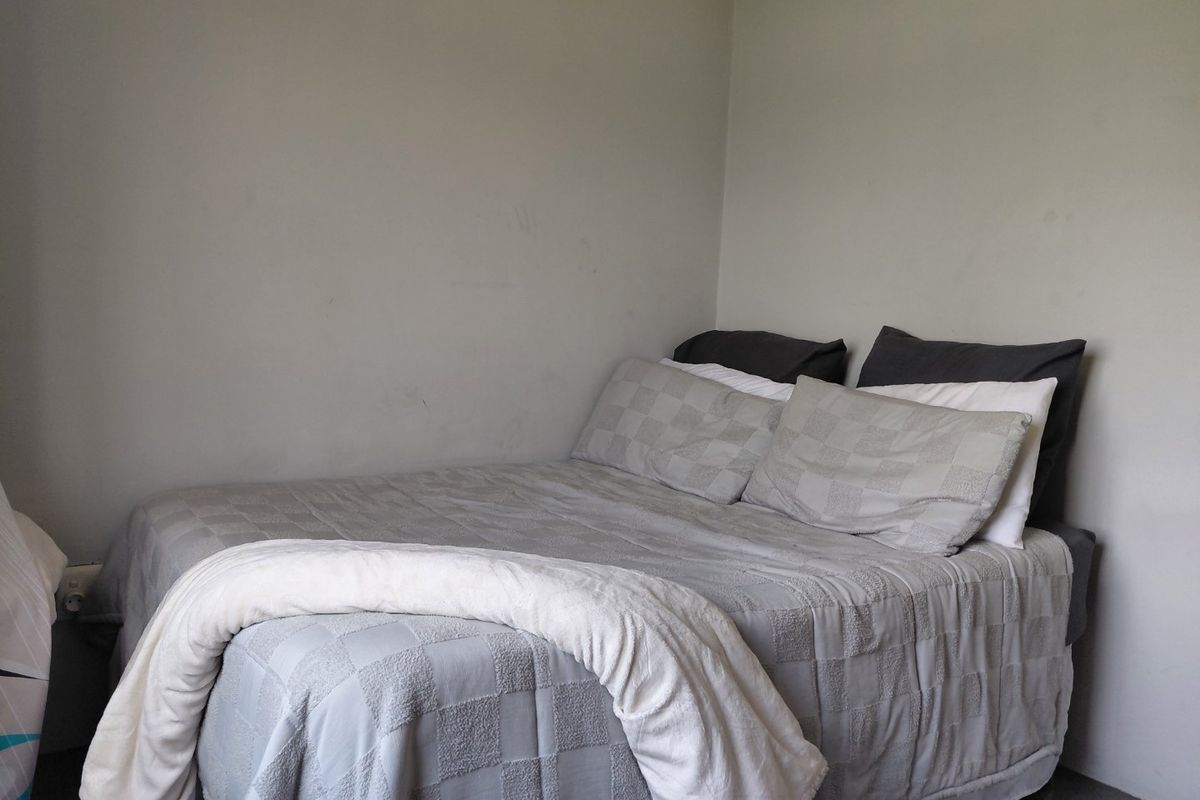 A simple bedroom space with neutral wall finishes, suitable for a variety of interior design styles.