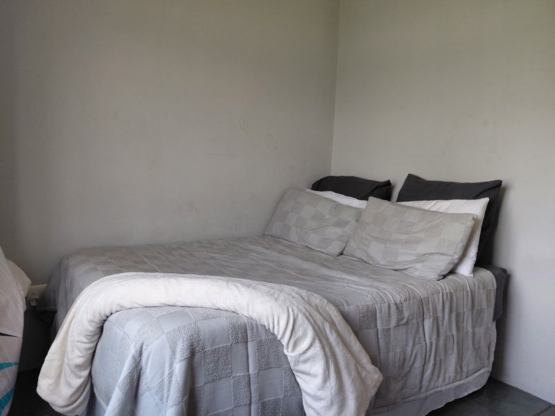 A simple bedroom space with neutral wall finishes, suitable for a variety of interior design styles.