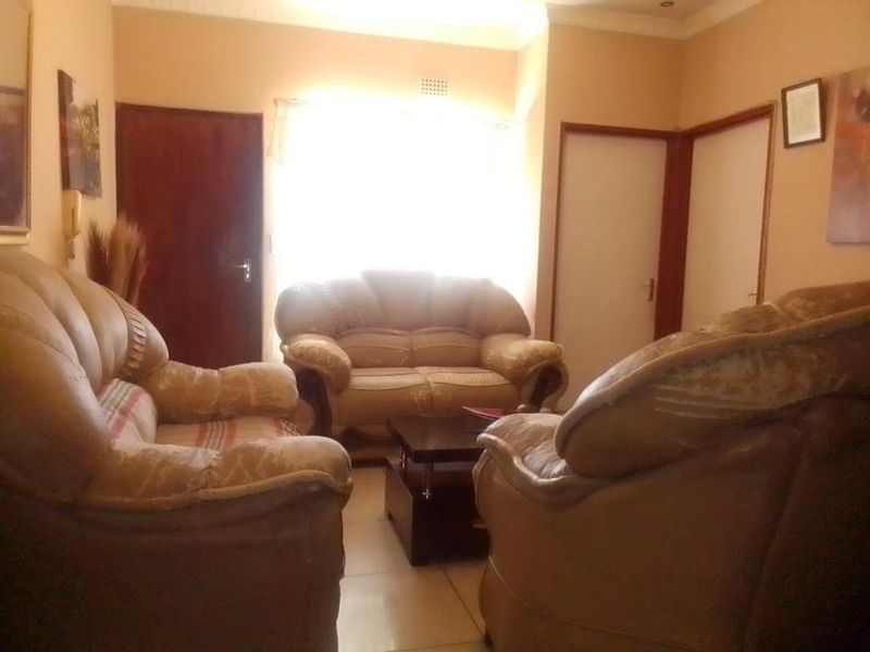 A living room area featuring tiled flooring and standard internal doors, providing a functional space for relaxation.