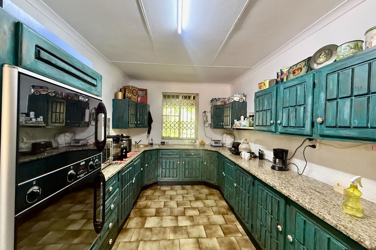 A functional kitchen featuring U-shaped cabinetry with granite countertops, built-in oven, and tiled flooring, offering a classic layout with potential for modern updates.