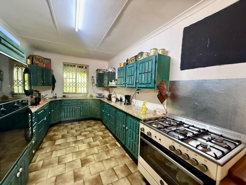 Spacious kitchen featuring extensive built-in cabinetry, granite countertops, and a gas stove, offering a functional layout with potential for modern updates.