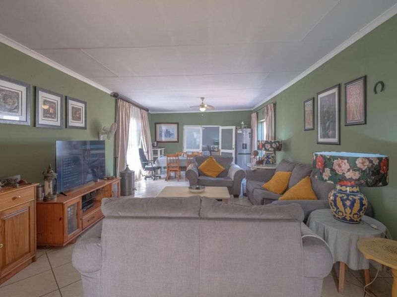 Spacious open-plan living and dining area featuring tiled flooring, a ceiling fan, and direct access to the outdoor space through sliding glass doors.