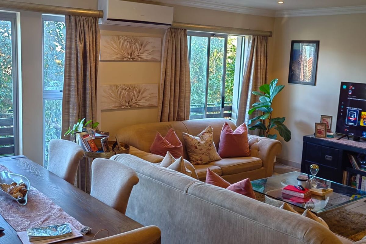 An open-plan living and dining area featuring tiled flooring, recessed lighting, and sliding glass doors that provide natural light and access to the exterior.