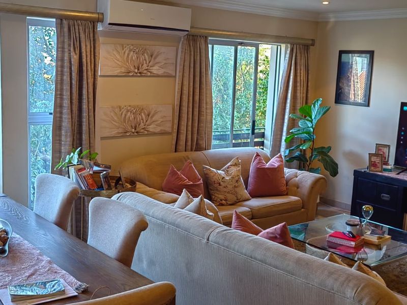 An open-plan living and dining area featuring tiled flooring, recessed lighting, and sliding glass doors that provide natural light and access to the exterior.