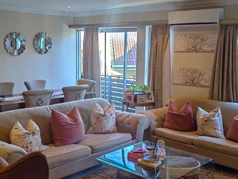Spacious open-plan living and dining area featuring large sliding glass doors, recessed lighting, and a wall-mounted air conditioning unit.