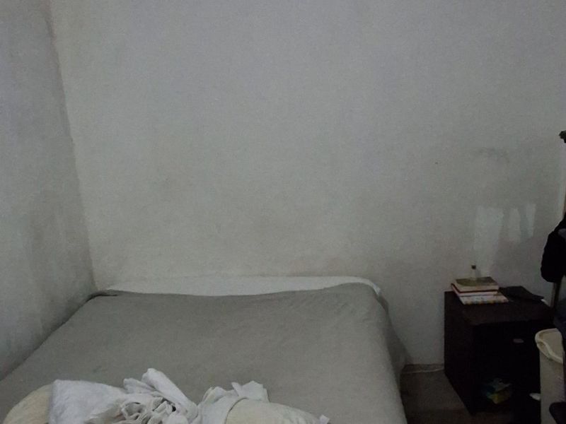 A bedroom space featuring plain walls and a ceiling, currently requiring cosmetic updates and maintenance to improve its overall condition.