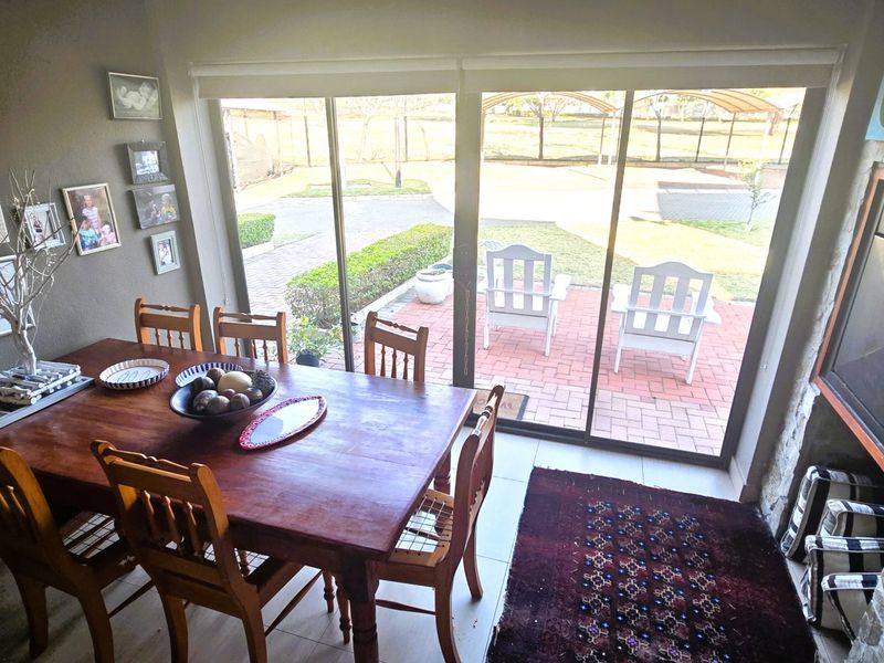 Dining room featuring a built-in fireplace with stone cladding and large sliding glass doors providing direct access to the outdoor patio and garden.