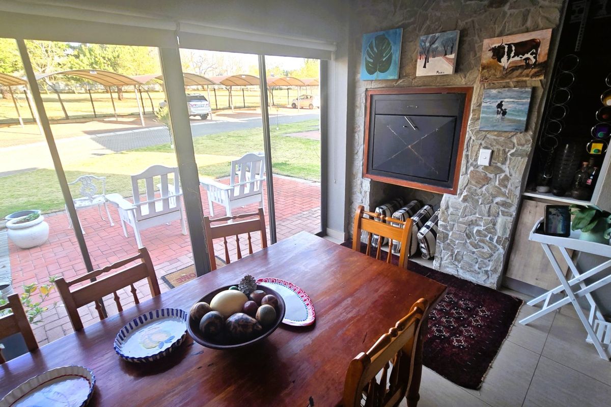 Living area featuring a stone-clad built-in fireplace and large sliding glass doors providing direct access to the outdoor patio and garden area.