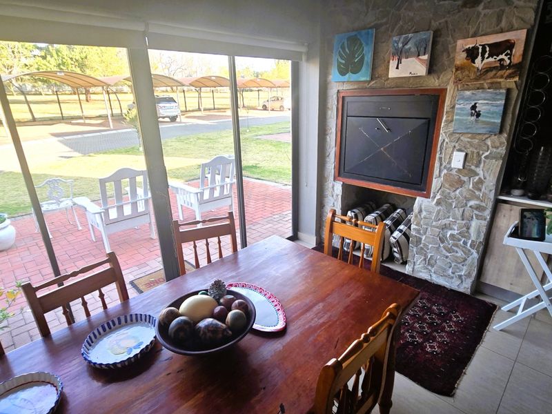 Living area featuring a stone-clad built-in fireplace and large sliding glass doors providing direct access to the outdoor patio and garden area.