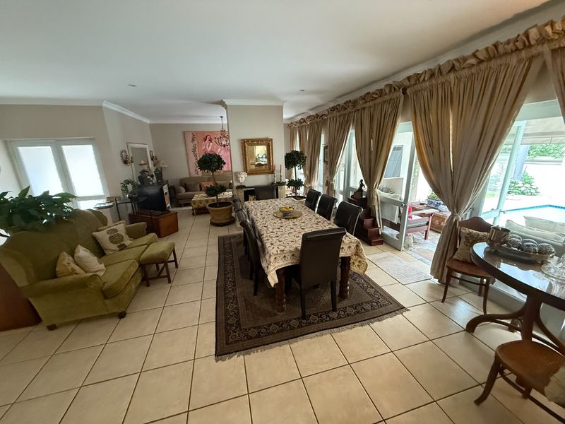 Spacious open-plan living and dining area featuring ceramic floor tiles, a fireplace, and large sliding glass doors providing access to the outdoor patio.