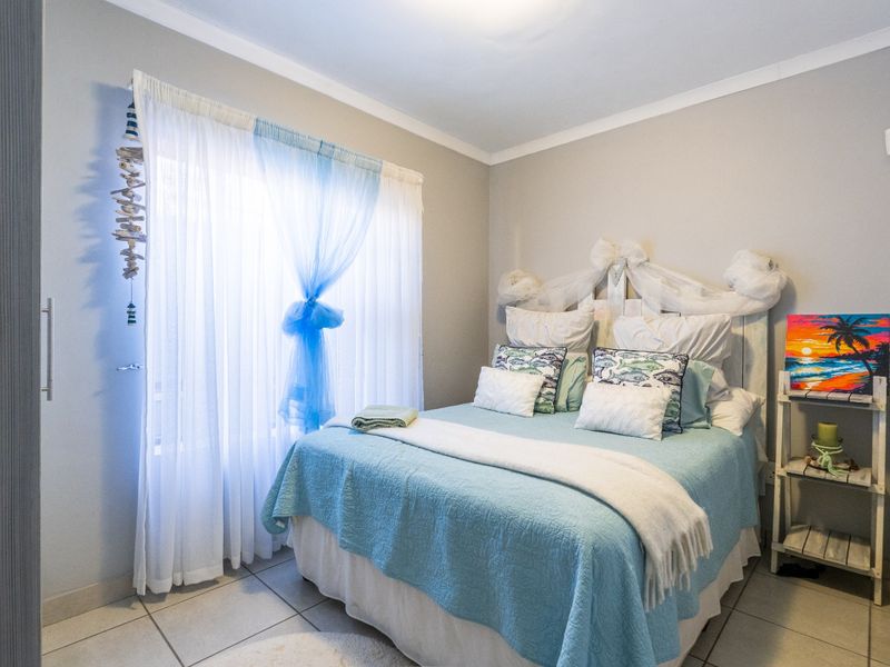 A well-maintained bedroom featuring neutral wall tones, tiled flooring, and a built-in cupboard, offering a comfortable and functional living space.