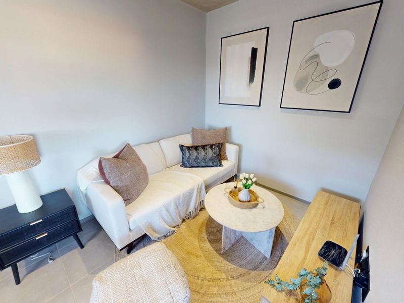 A compact and well-maintained living area featuring neutral wall tones and tiled flooring, creating a cozy and inviting atmosphere.