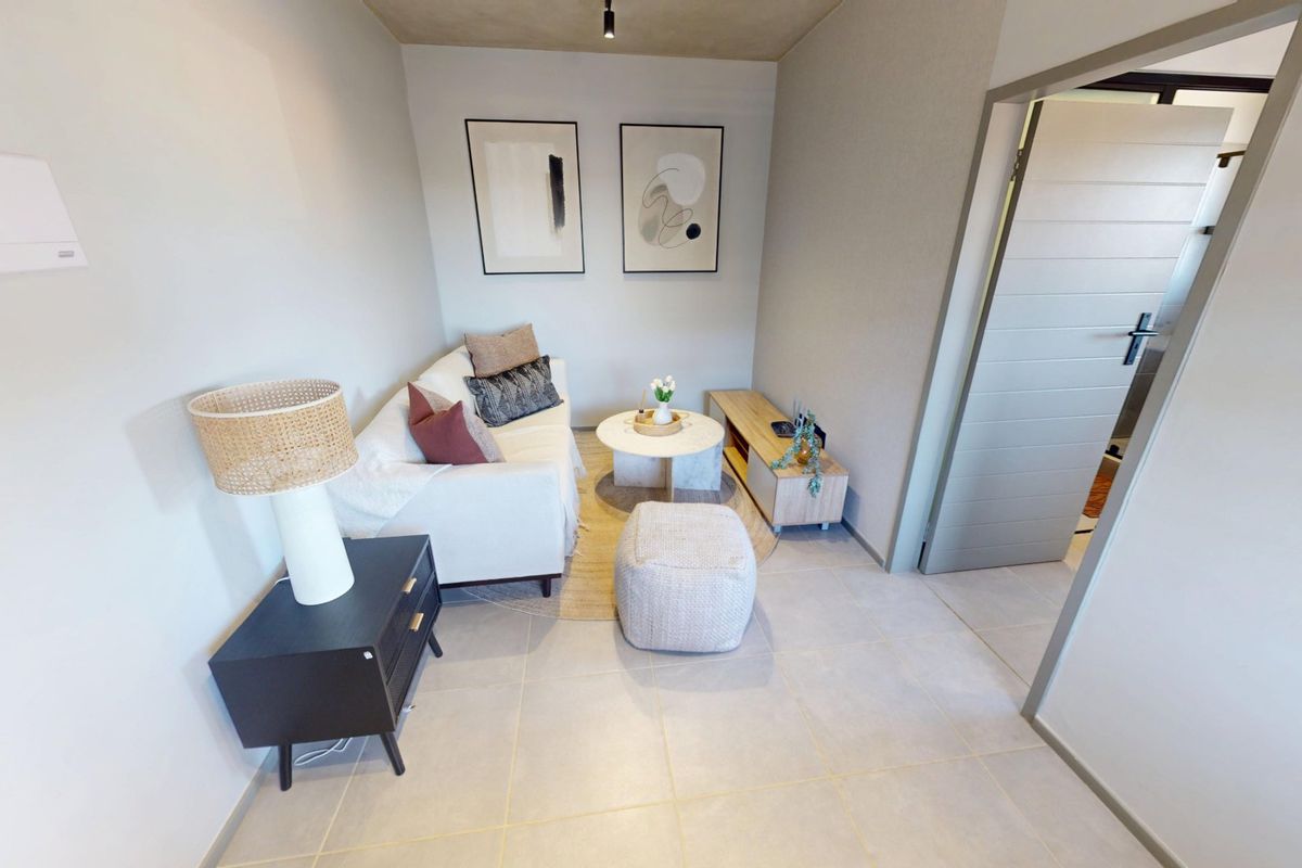 A compact, well-maintained living area featuring neutral tiled flooring and modern finishes, providing a functional and inviting space.