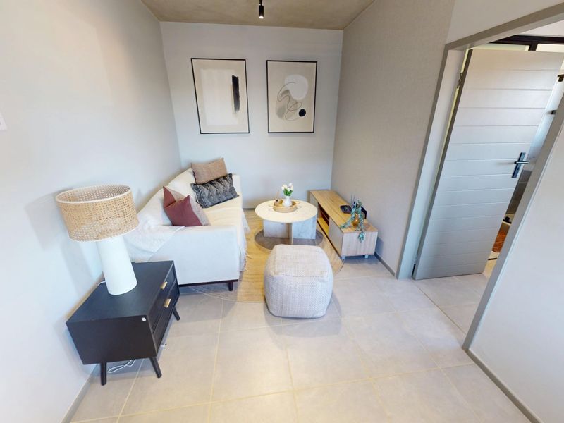 A compact, well-maintained living area featuring neutral tiled flooring and modern finishes, providing a functional and inviting space.
