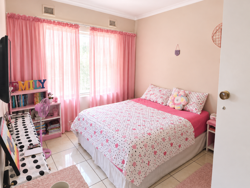 A bedroom featuring tiled flooring, neutral wall paint, and a window with curtain tracks.