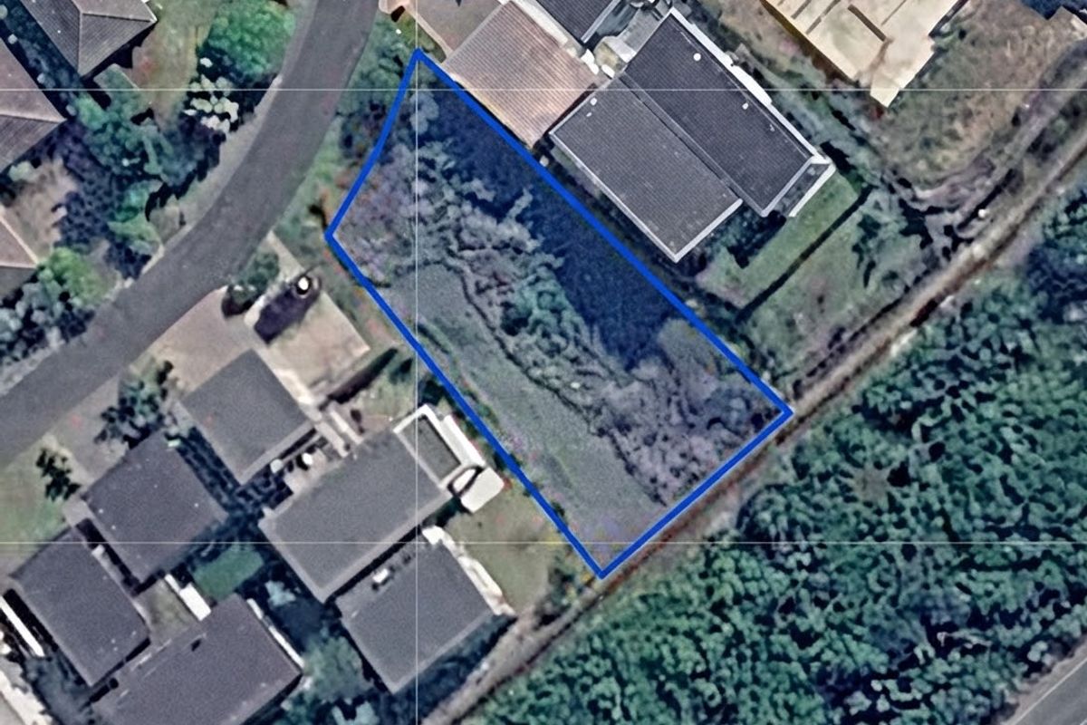 An aerial view of a vacant residential plot situated within a developed neighborhood, highlighting the available land area and surrounding property context.