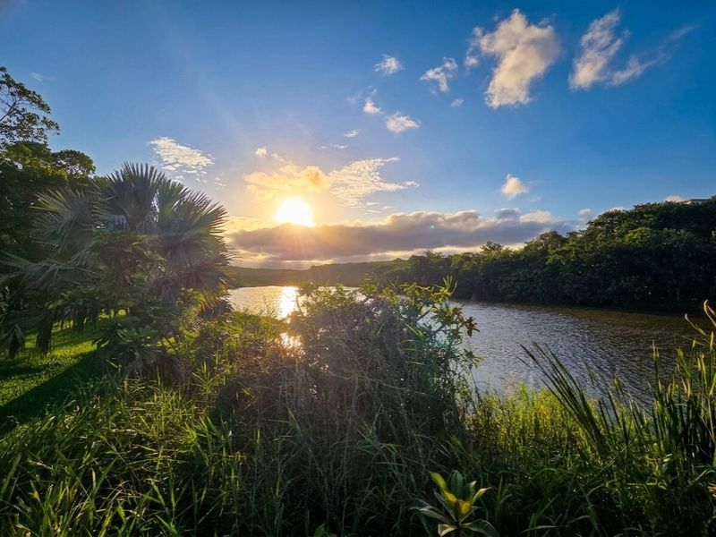 A scenic view of a tranquil river at sunset, showcasing the natural beauty and peaceful surroundings of the vacant land.