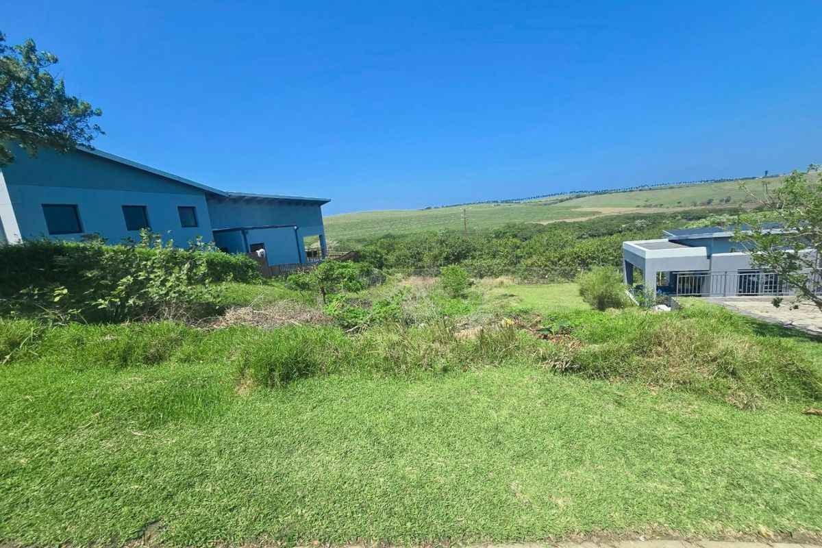A view of the sloped residential vacant land with surrounding established properties and natural landscape.