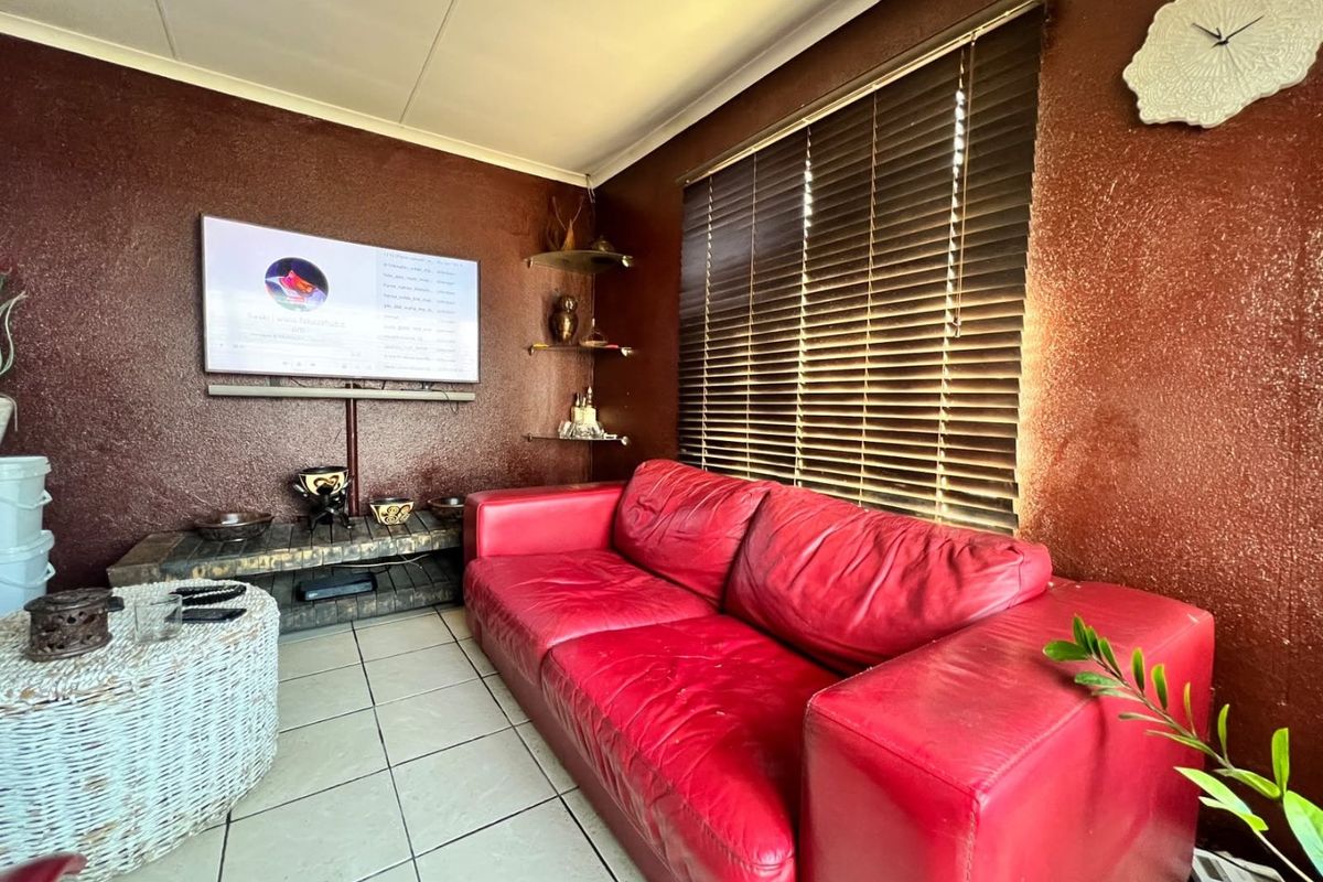 A cozy living room featuring tiled flooring, coved ceilings, and venetian blinds, providing a functional space with potential for modern updates.