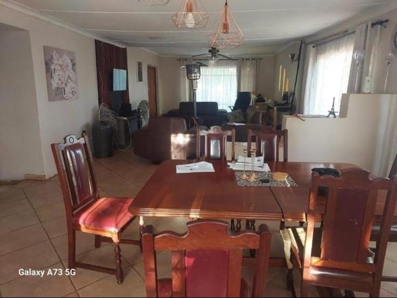 Spacious open-plan living and dining area featuring tiled flooring, ceiling fan, and modern pendant lighting, offering a versatile layout for family living.