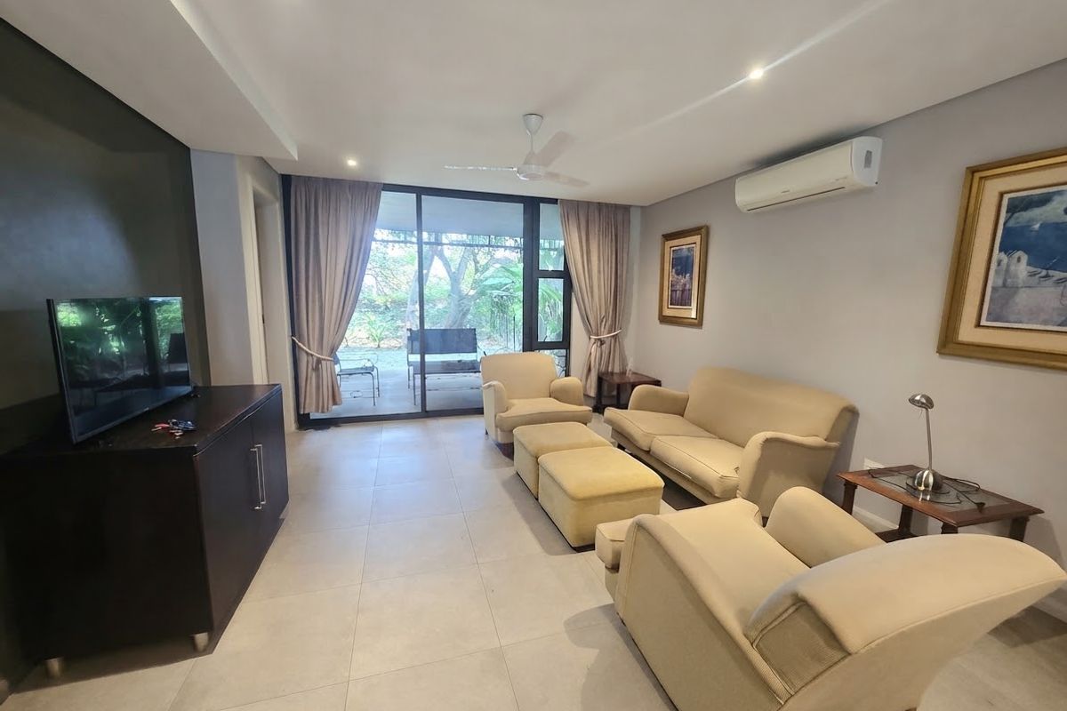 A well-maintained living room featuring tiled floors, recessed lighting, a ceiling fan, and a split-system air conditioner, with direct access to an outdoor patio.