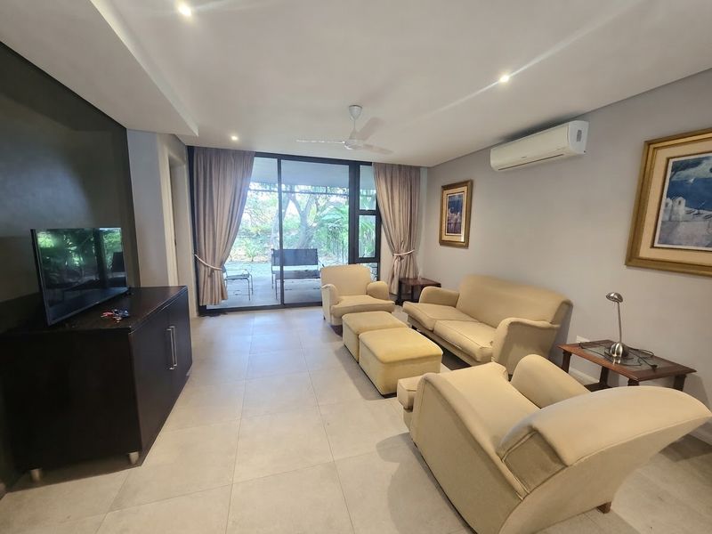 A well-maintained living room featuring tiled floors, recessed lighting, a ceiling fan, and a split-system air conditioner, with direct access to an outdoor patio.