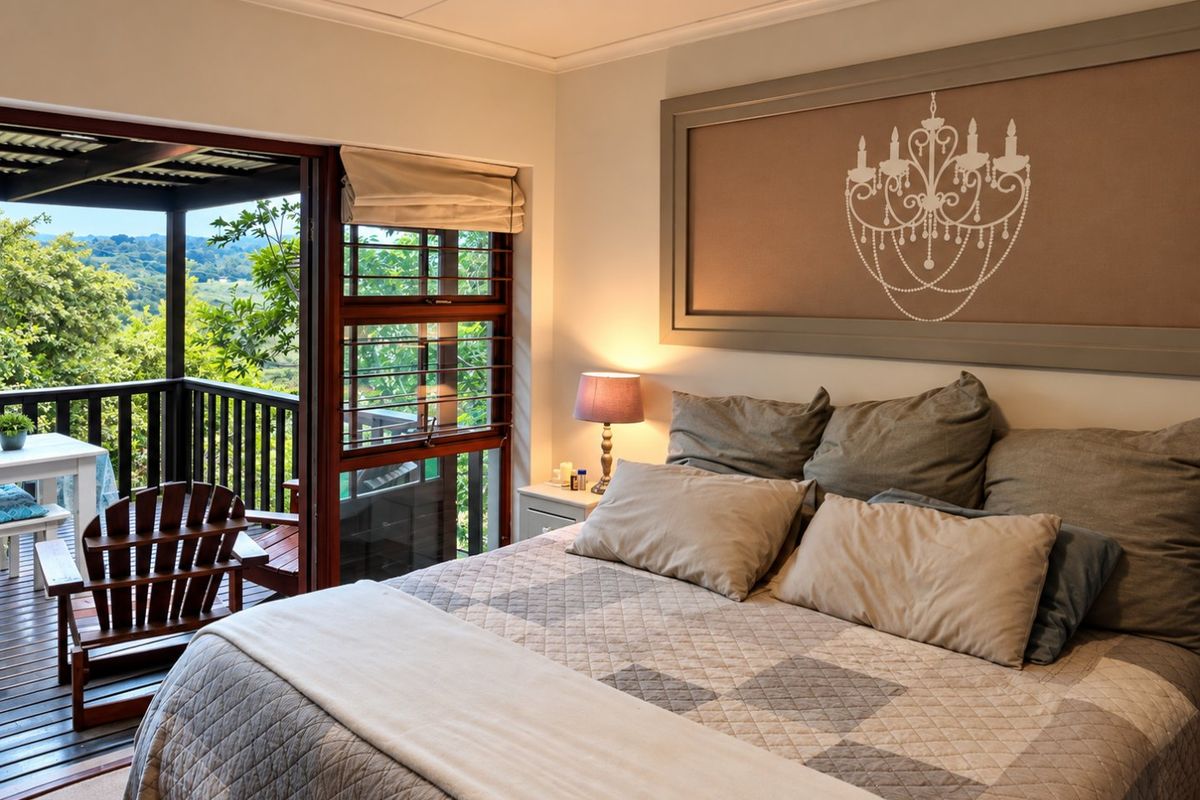 A well-maintained bedroom featuring timber-framed windows and a sliding door that opens onto a private balcony with scenic views.