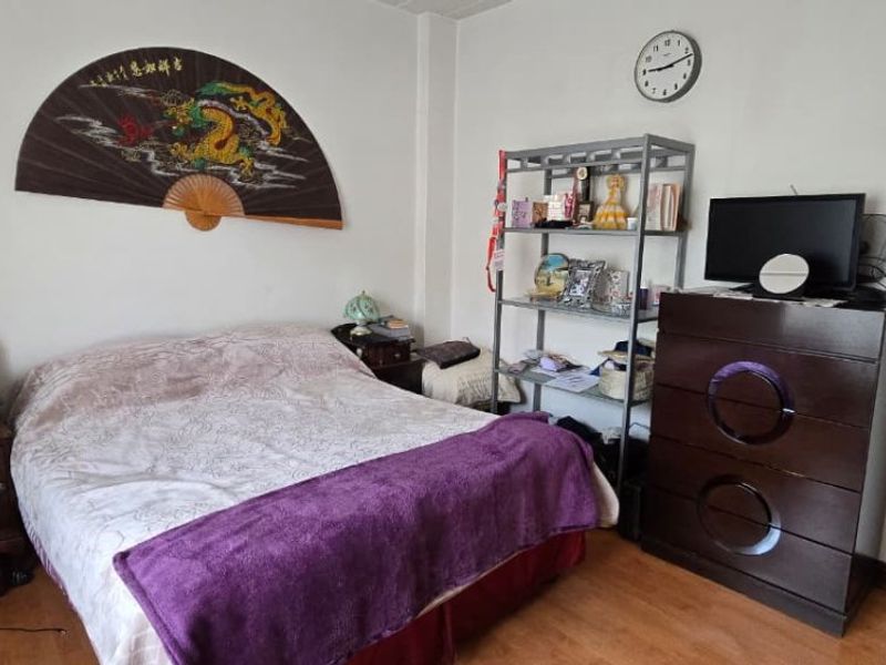 A standard bedroom featuring laminate flooring and neutral wall finishes, providing a functional space for rest.