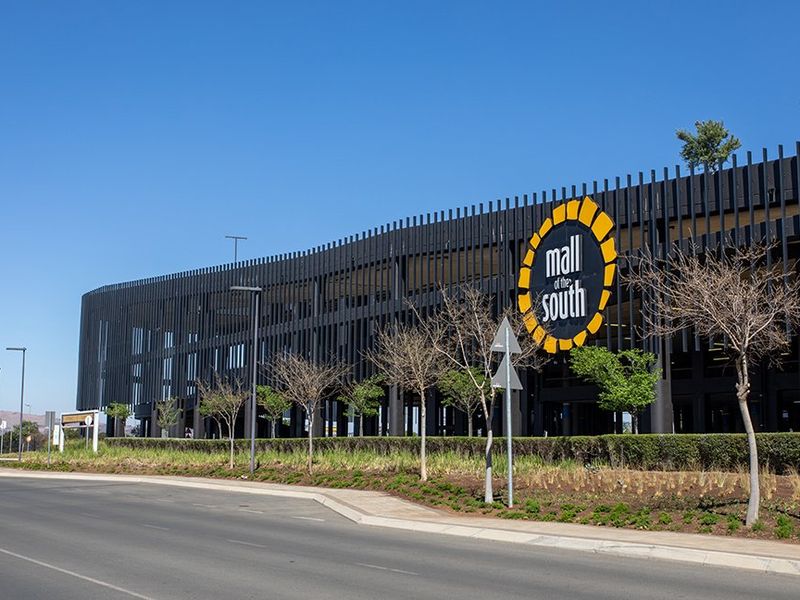 A clear exterior view of the Mall of the South commercial property, showcasing its modern architectural facade, parking structure, and well-maintained landscaped surroundings.