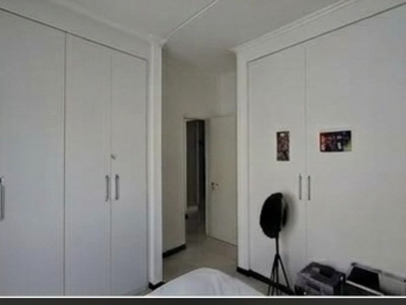 Bedroom featuring extensive floor-to-ceiling built-in cupboards providing ample storage space.