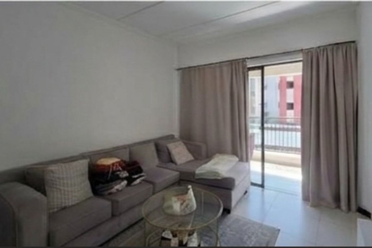 A living room area featuring tiled flooring and a sliding glass door providing access to an outdoor balcony space.